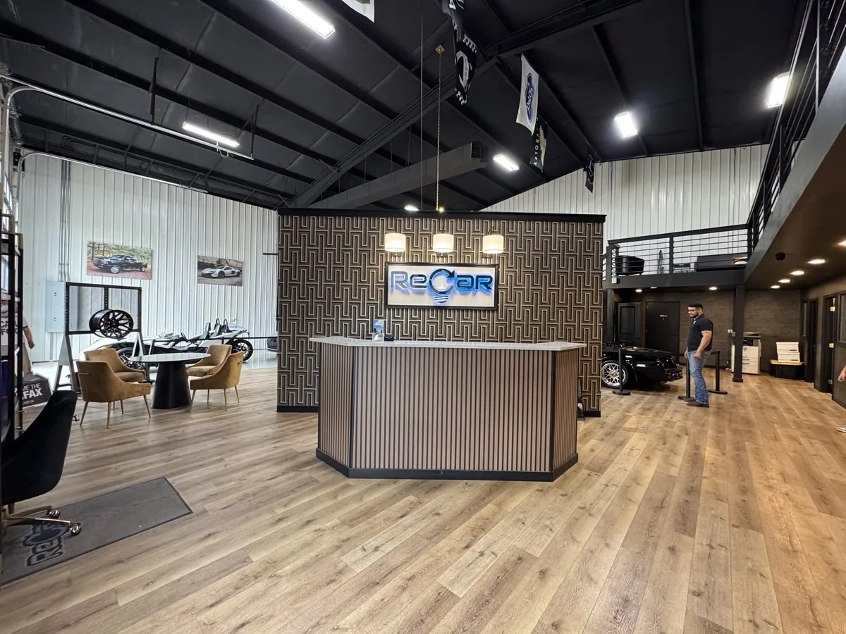 ReCar showroom reception desk beneath the lighted ReCar sign